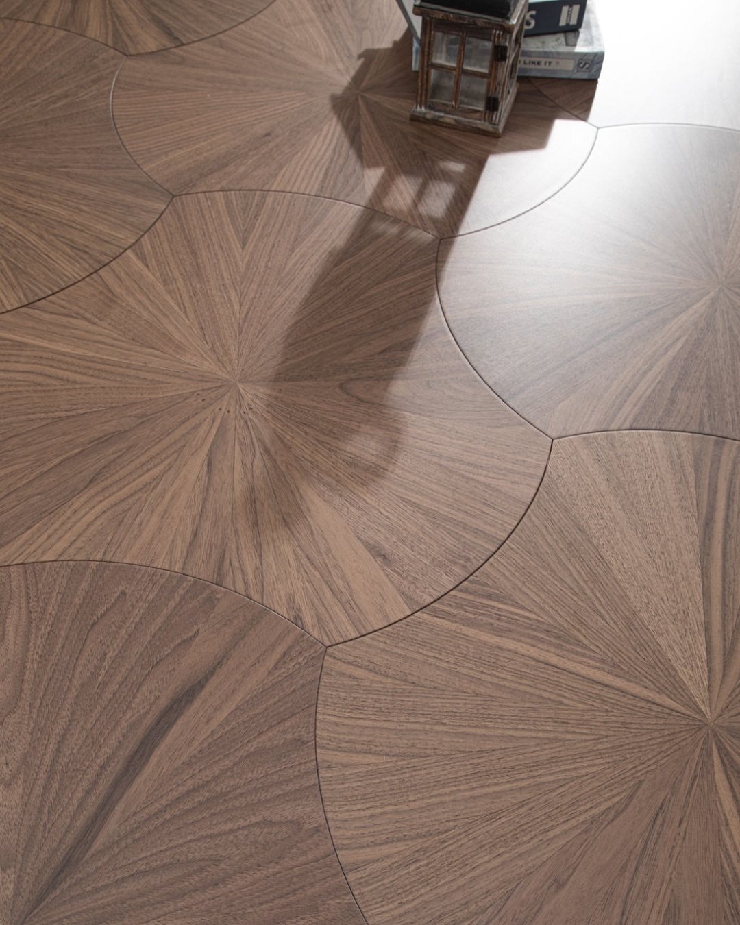 Dark wood floor with a decorative circular sunburst pattern made of interlocking wood grain segments.