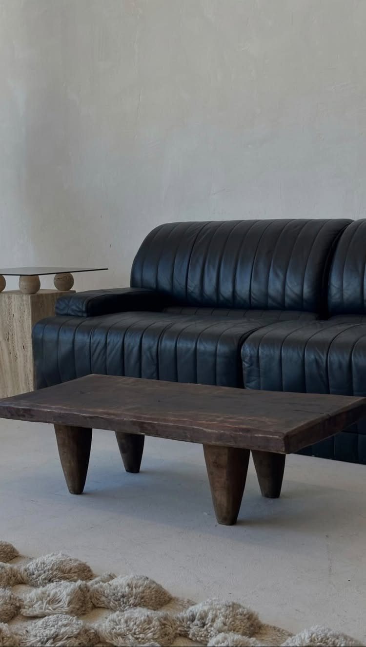 Dark Brown Wood Colors: 13 Ideas for Your Home 11 A dark brown wooden coffee table with thick legs in a minimalist living room.