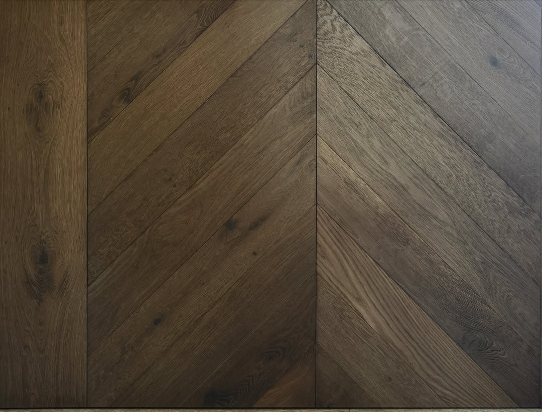 Dark Brown Wood Colors: 13 Ideas for Your Home 4 Dark brown wood flooring planks arranged in a decorative herringbone pattern with visible grain.