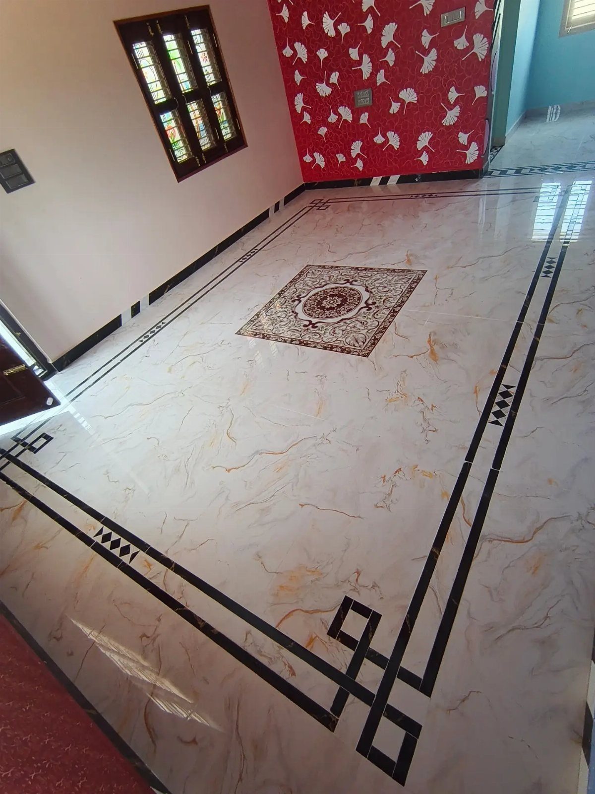 Marble-look floor tiles featuring a dark geometric decorative border and a central medallion design.
