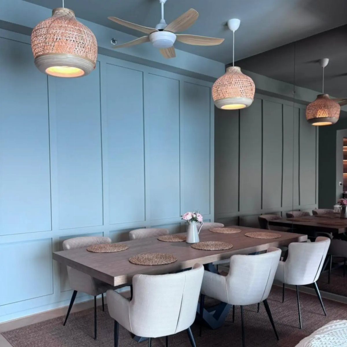 Light blue flat panel wainscoting in a modern dining room with a wooden table.