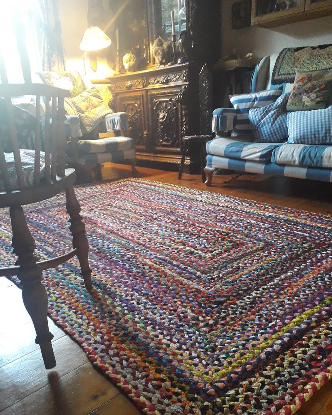 Colorful crocheted rag rug on a wooden floor in a cozy living room.