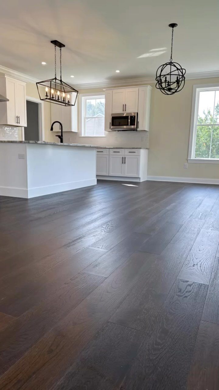 9 Chocolate Brown Hardwood Floors Ideas for Every Room 3 Dark chocolate brown hardwood floors with visible grain in a modern white kitchen setting.