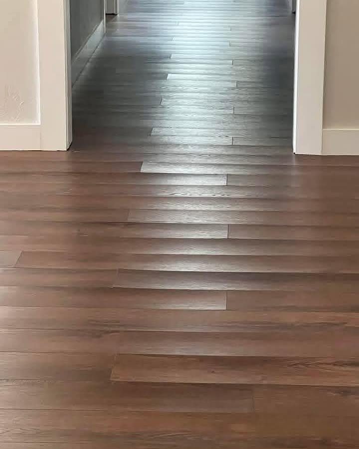 Staggered wood floor planks creating a stair step pattern leading through a doorway.