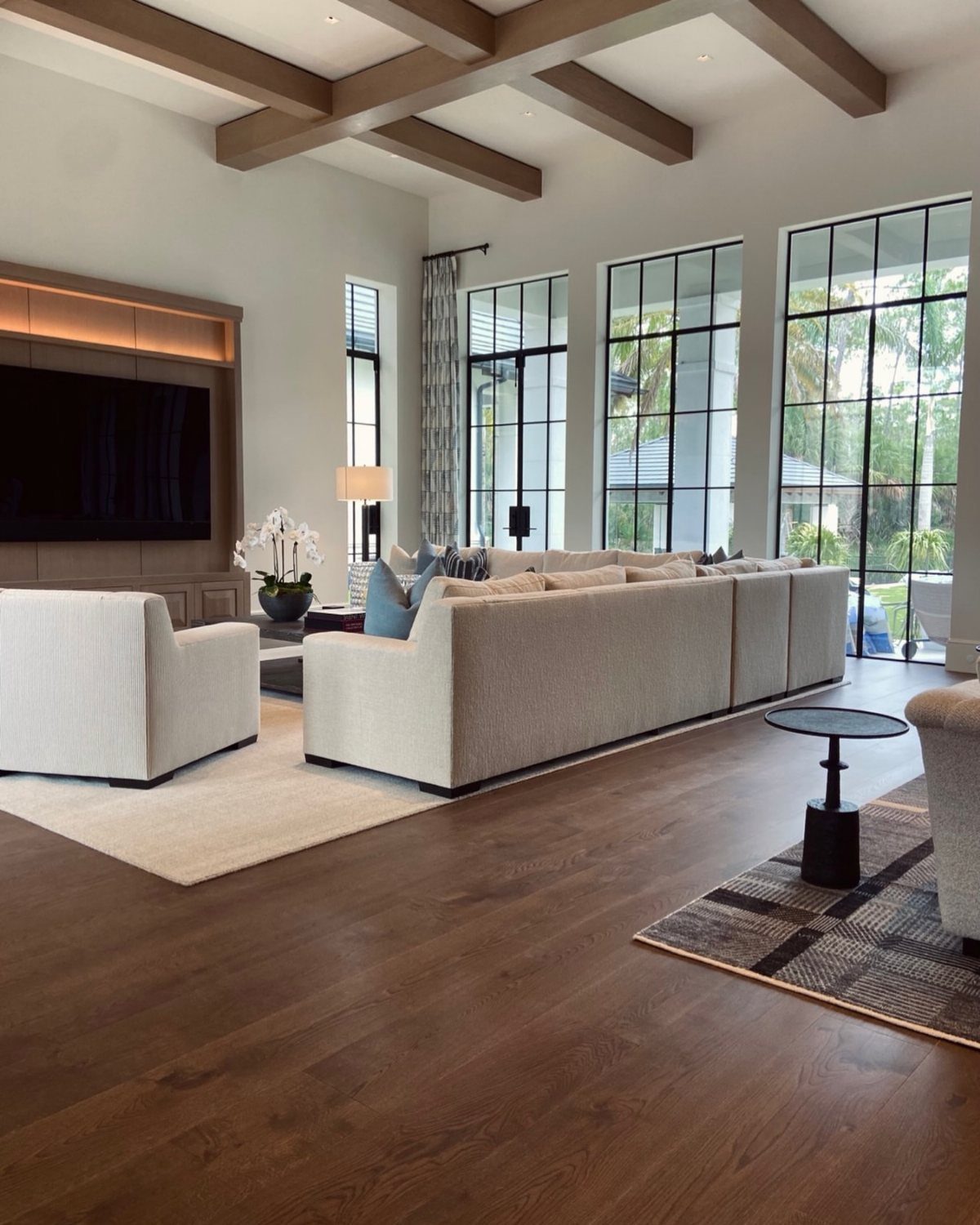 9 Chocolate Brown Hardwood Floors Ideas for Every Room 9 Dark chocolate brown hardwood floors in a modern, sunlit living room with beige furniture.