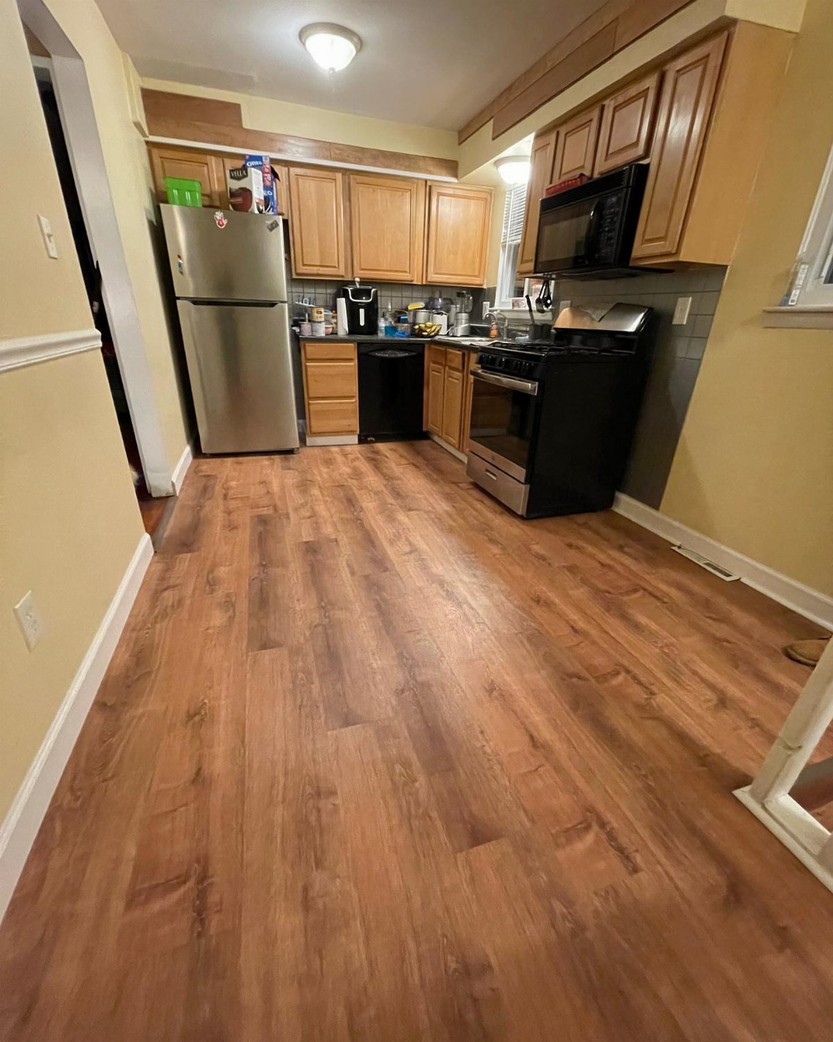 Vinyl Flooring with Oak Cabinets: 3 Ways to Make It Work 1 Honey oak kitchen cabinets paired with warm brown wood-look luxury vinyl plank flooring.