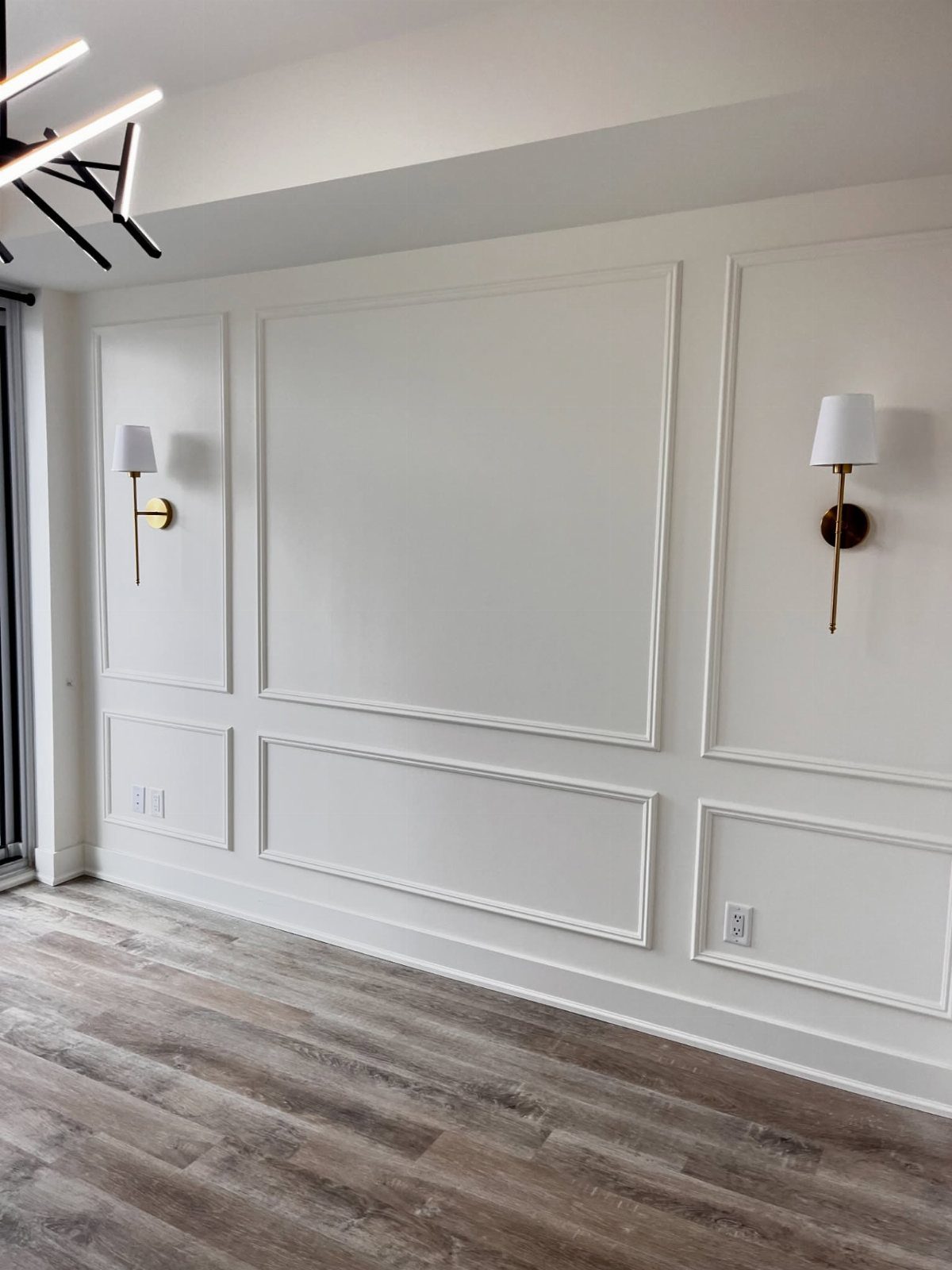5 Wall Panelling for Living Room Ideas That Add Real Texture 2 White wall with decorative picture frame moulding and wainscoting in a living room.