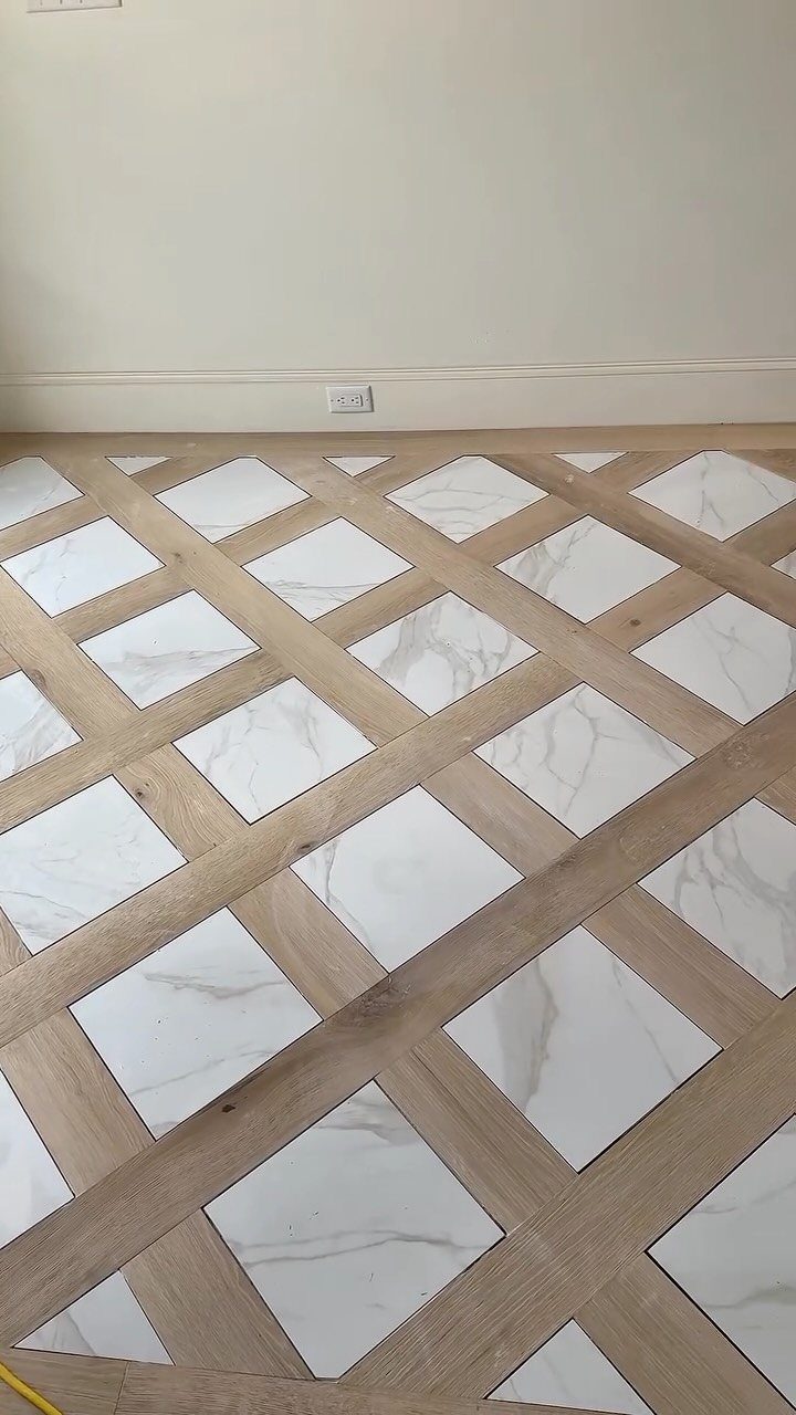11 Luxury Living Room Flooring Ideas for 2026 8 Geometric floor pattern with light wood strips and white marble diamond tiles.
