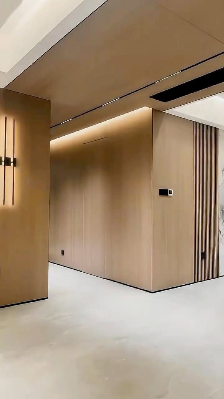 Modern interior featuring light wood wall panels and a matching wood ceiling with minimalist design elements.